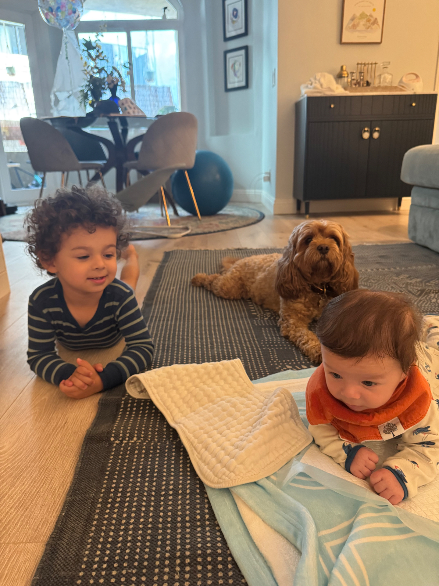 Ethan, the dog, and Ollie all hanging out on the living room floor during tummy time