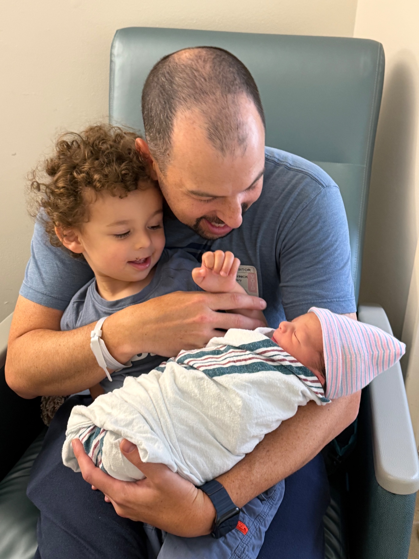 Jeremy holding newborn Ollie with big brother Ethan in the hospital