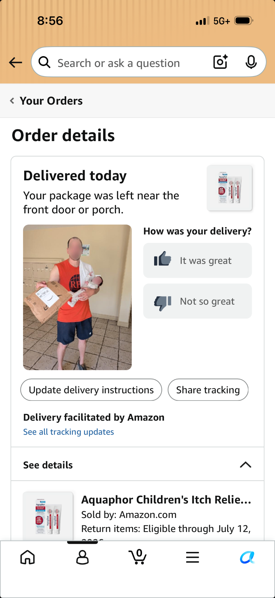 Jeremy holding Ollie at the door receiving an Amazon delivery